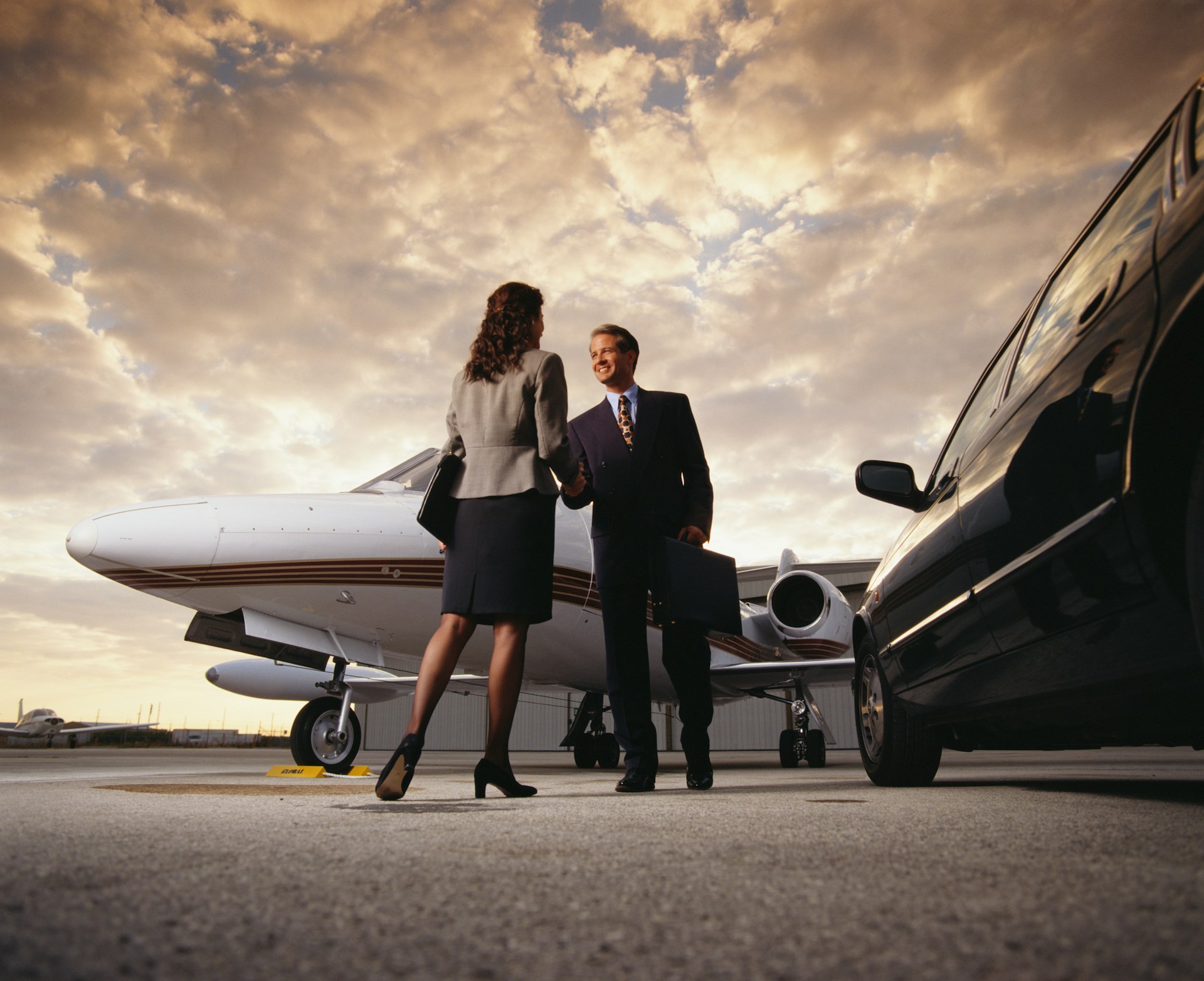 Private jet and executive vehicle on an airport tarmac